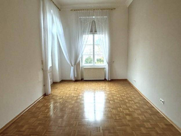 Ruhiges Schlafzimmer mit Parkettboden und einem Fenster, das eine helle und freundliche Atmosphäre bietet.