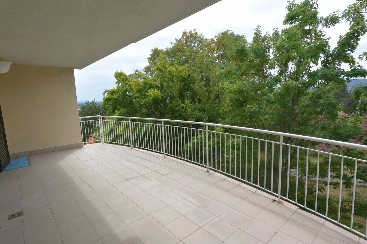 Geräumiger Balkon mit Fliesenboden und weißem Geländer, ideal für individuelle Gestaltung und Entspannung im Freien.
