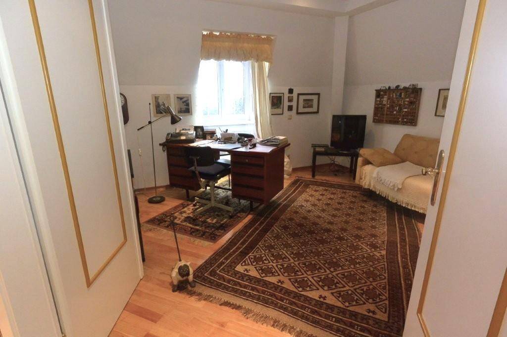 Funktionales Arbeitszimmer mit Schreibtisch, Stuhl und Sofa, bietet einen hellen Raum für Produktivität und Entspannung.