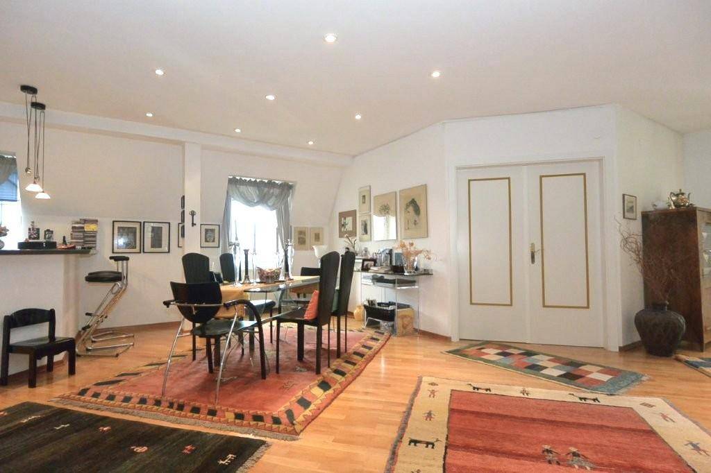 Heller Essbereich mit modernem Esstisch, Stühlen und einer Frühstücksbar, integriert in den offenen Wohnraum.