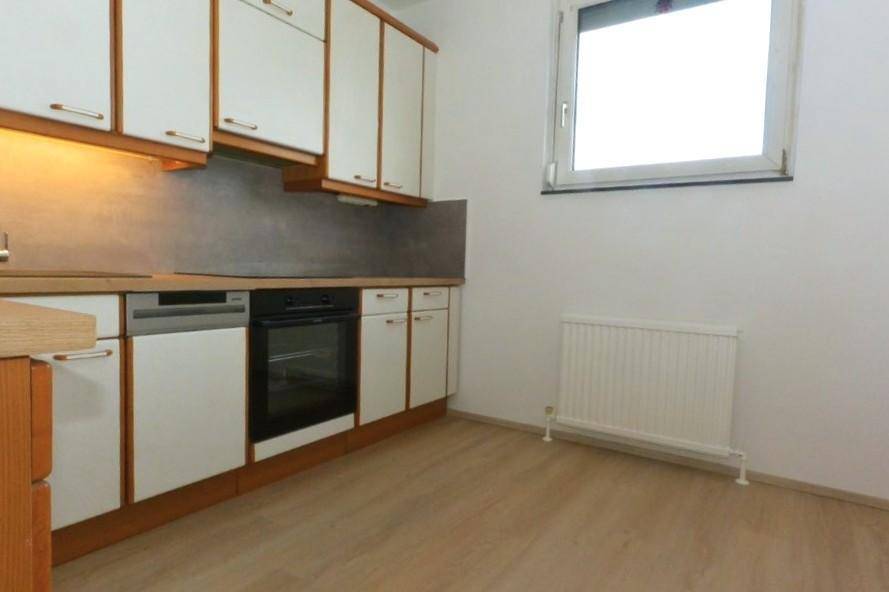 Küchenzeile mit Spüle, Geschirrspüler, Backofen und Fenster für natürliches Licht.