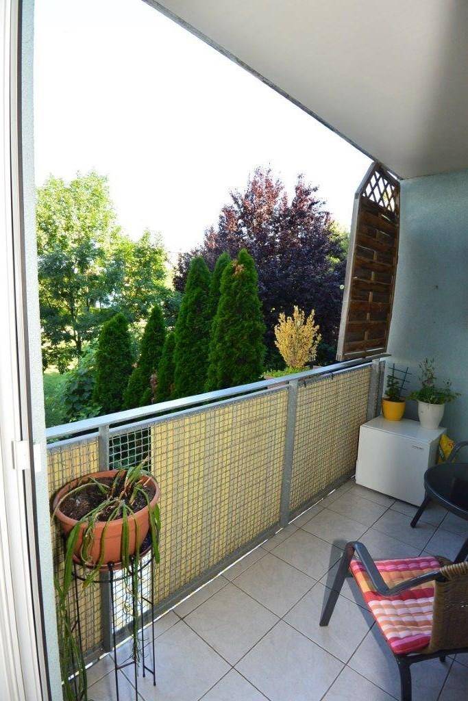 Gemütlicher Balkon mit Fliesenboden und Blick ins Grüne, ideal zum Entspannen im Freien.