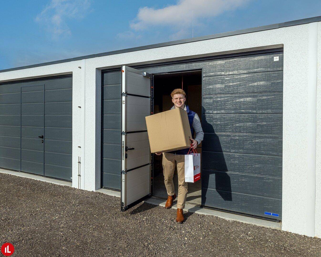 Ein Mann betritt eine moderne Lagerbox mit einer großen grauen Rolltür.