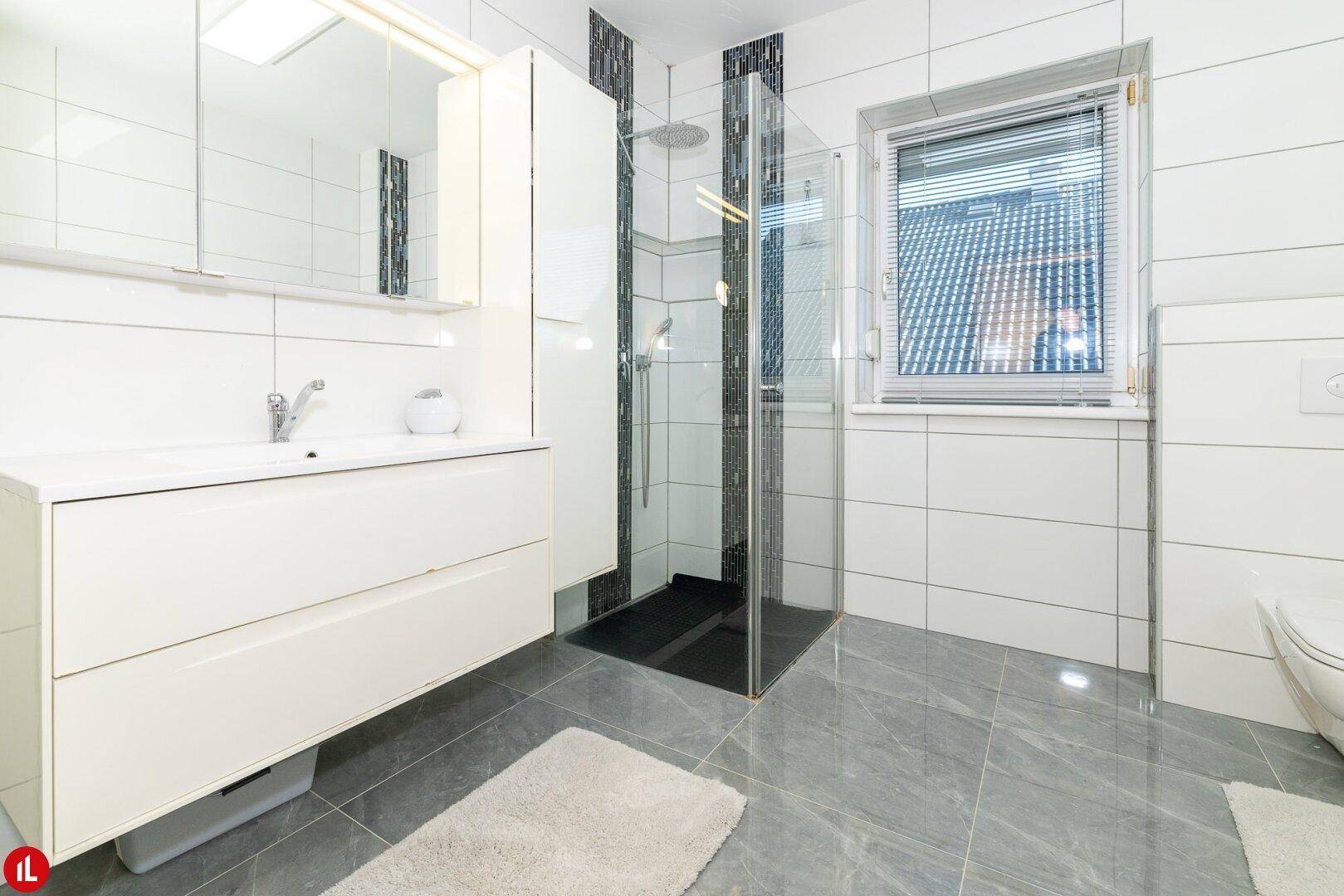 Modernes Badezimmer mit großer begehbarer Dusche, Einzelwaschbecken und Fenster.