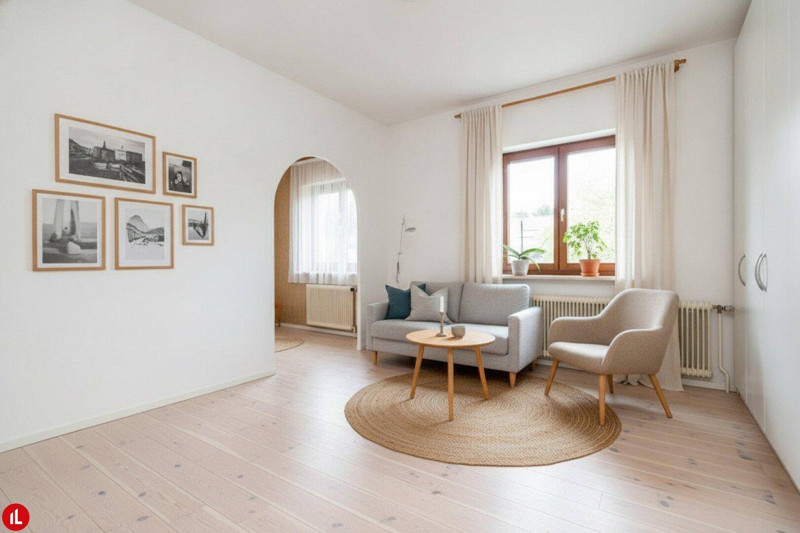 Helles Wohnzimmer mit hellem Holzboden, moderner Einrichtung und viel Tageslicht.