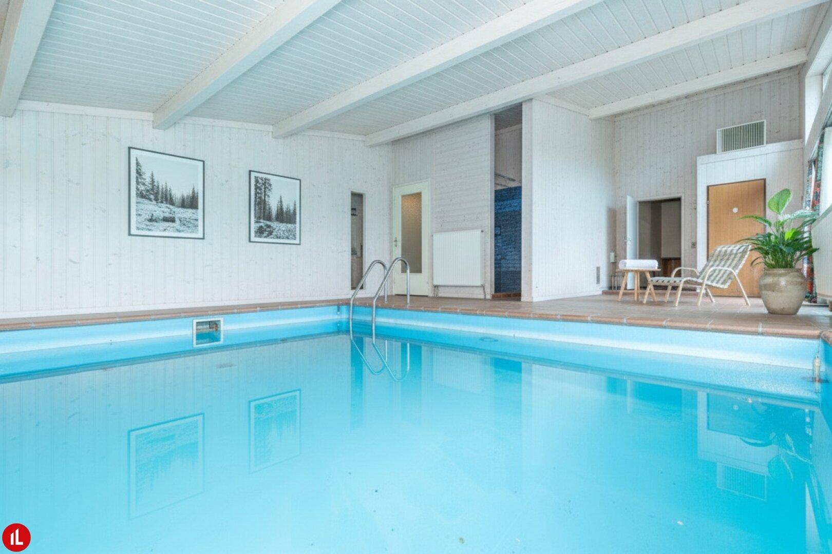 Modernisierter Innenpoolbereich mit weißer Holzverkleidung und viel Tageslicht.