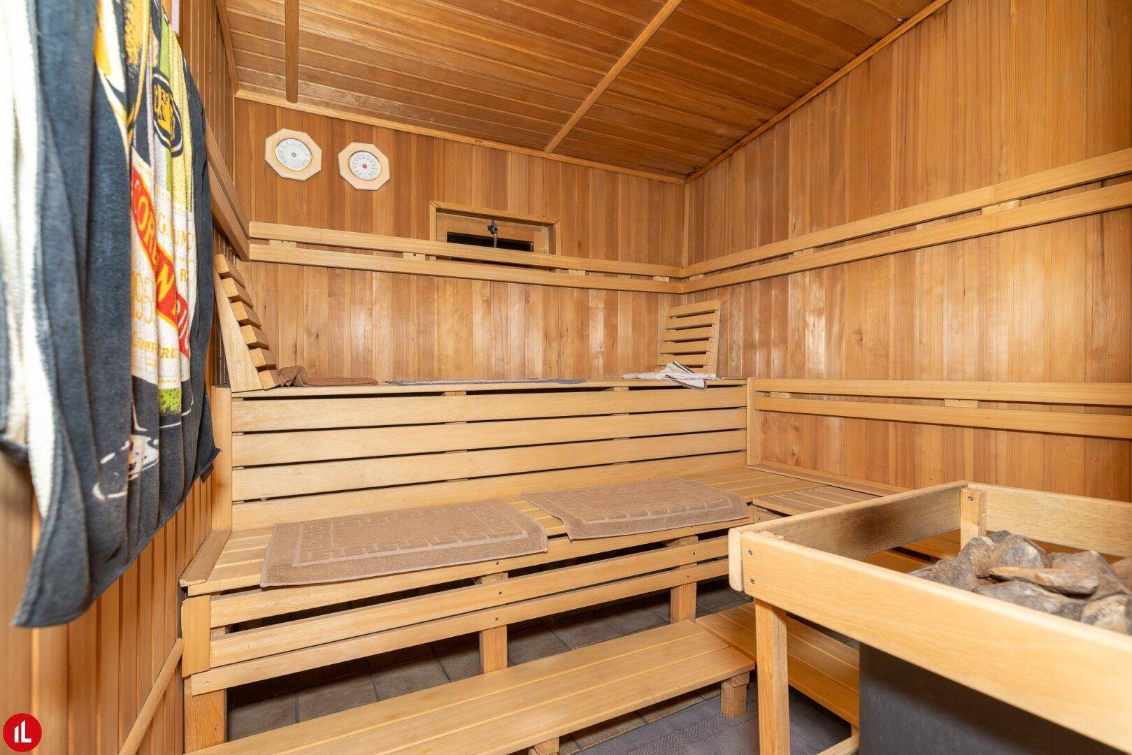 Geräumige Holzsauna mit mehreren Bänken und einem Saunaofen für Entspannung.