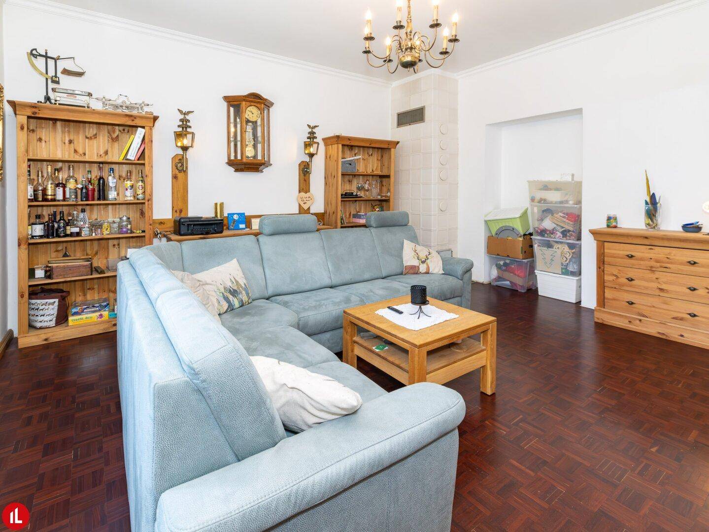 Wohnzimmer mit Ecksofa, rustikalen Holzregalen und einem praktischen Stauraum in der Nische.