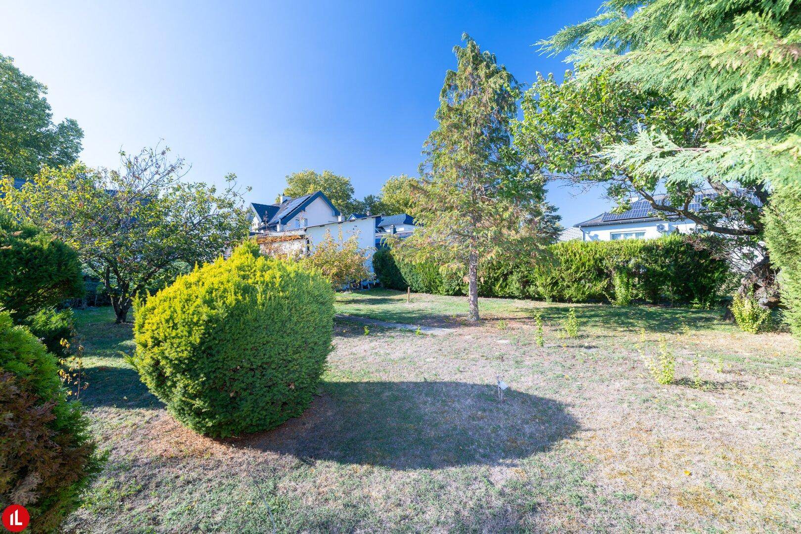 Gepflegter Garten mit Rasenfläche, Büschen und Hecken, bietet viel Privatsphäre.