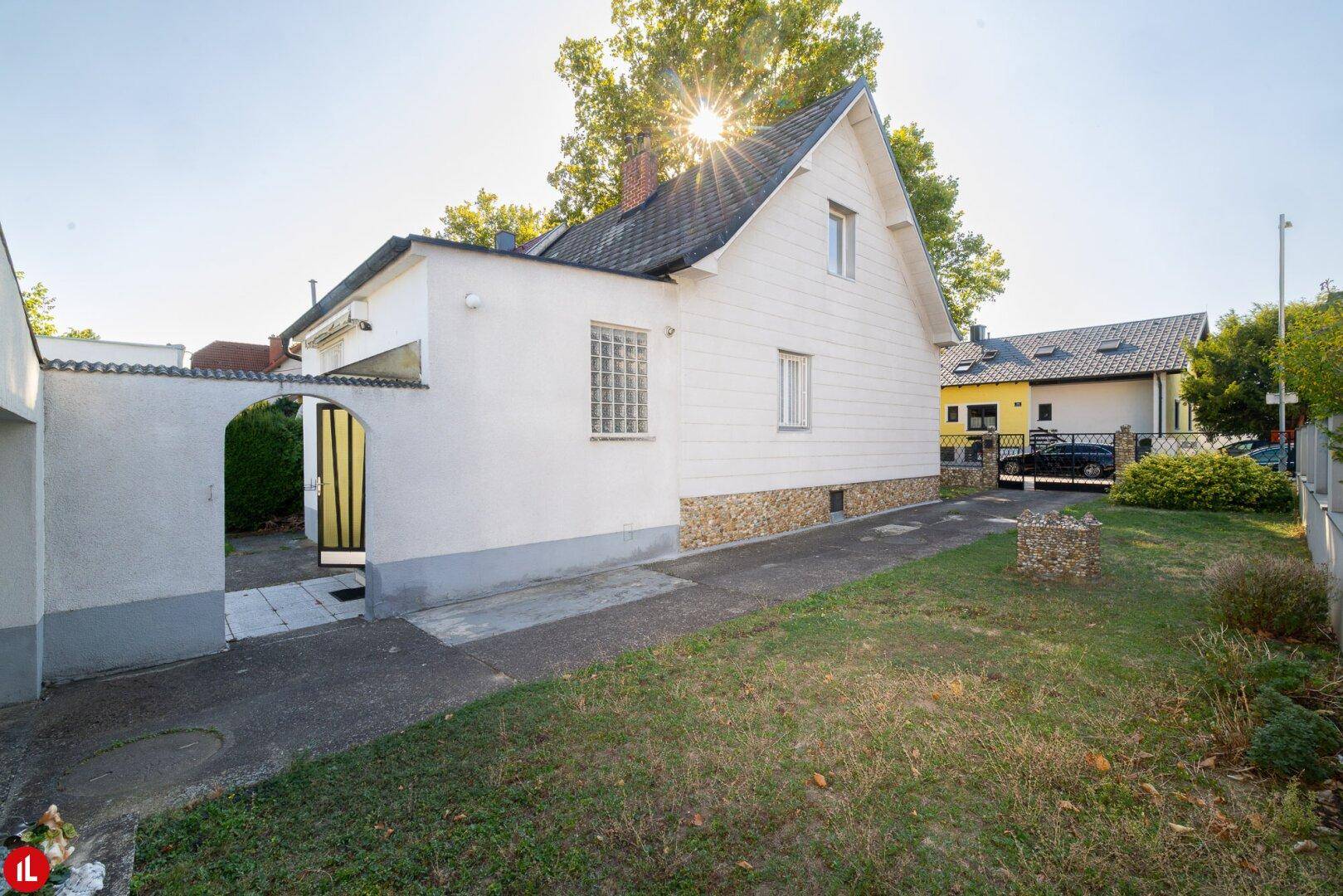 Rückansicht des Hauses mit kleinem Gartenbereich und Zugang zum Nebengebäude.