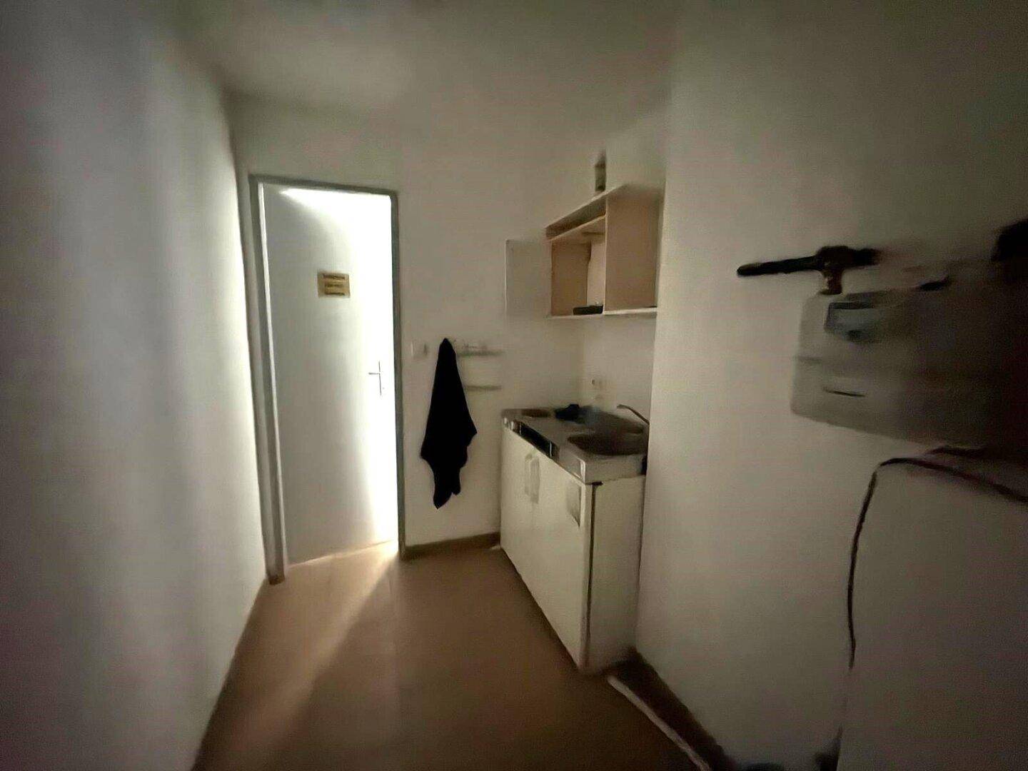 Kleine Kochnische in einem schmalen Raum mit Spüle und Schränken, ideal für eine einfache Verpflegung.