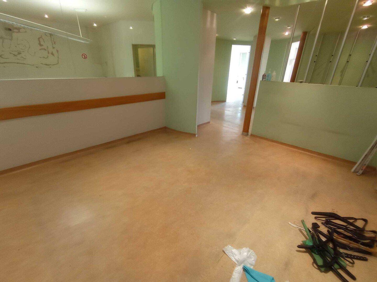 Innenraum mit hellgrünen Wänden und geschwungener Trennwand, bereit für die individuelle Gestaltung und Nutzung.