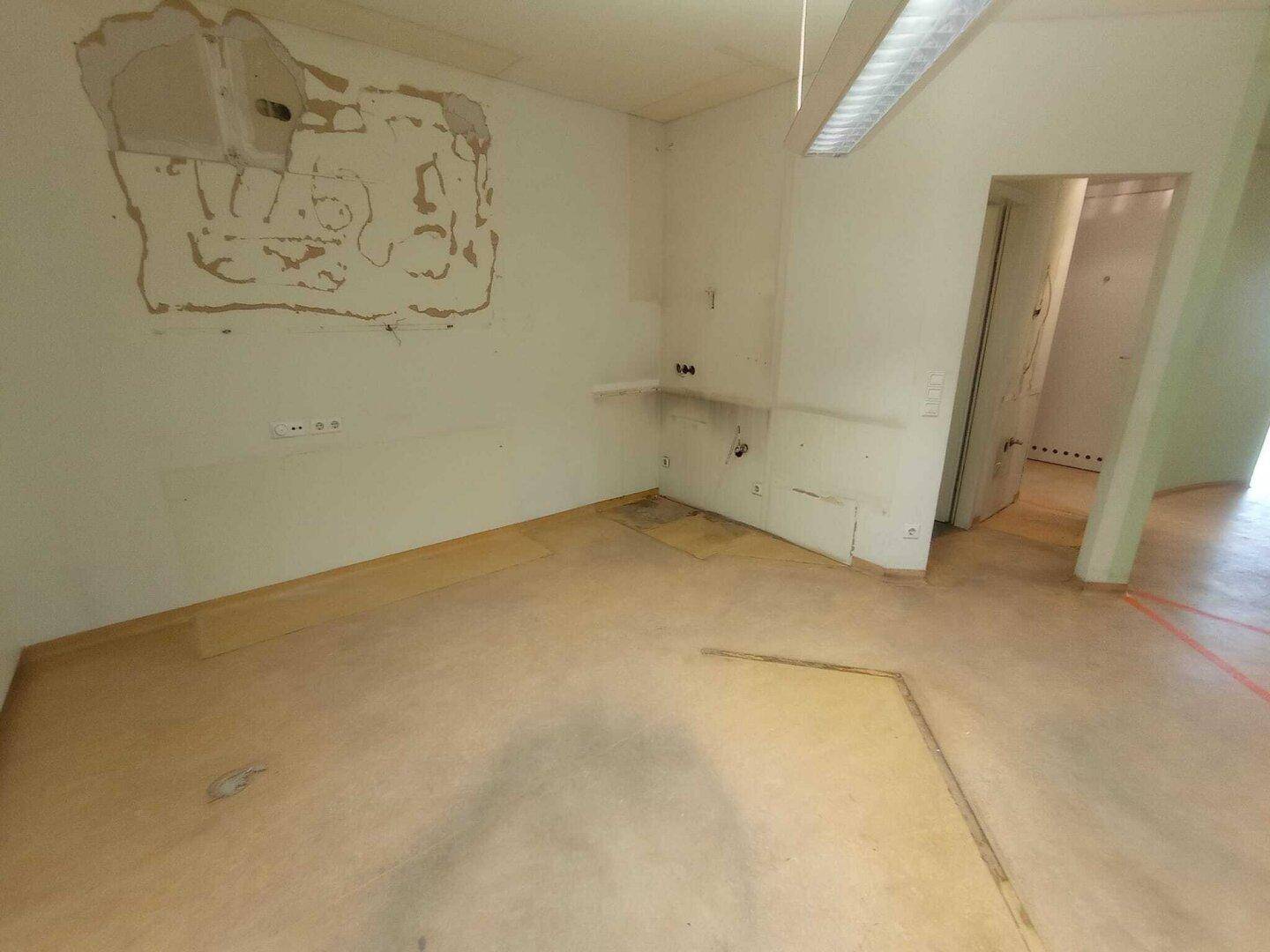 Innenraum mit beschädigten Wänden und Türöffnung, bietet Raum für eine umfassende Renovierung und Neugestaltung.