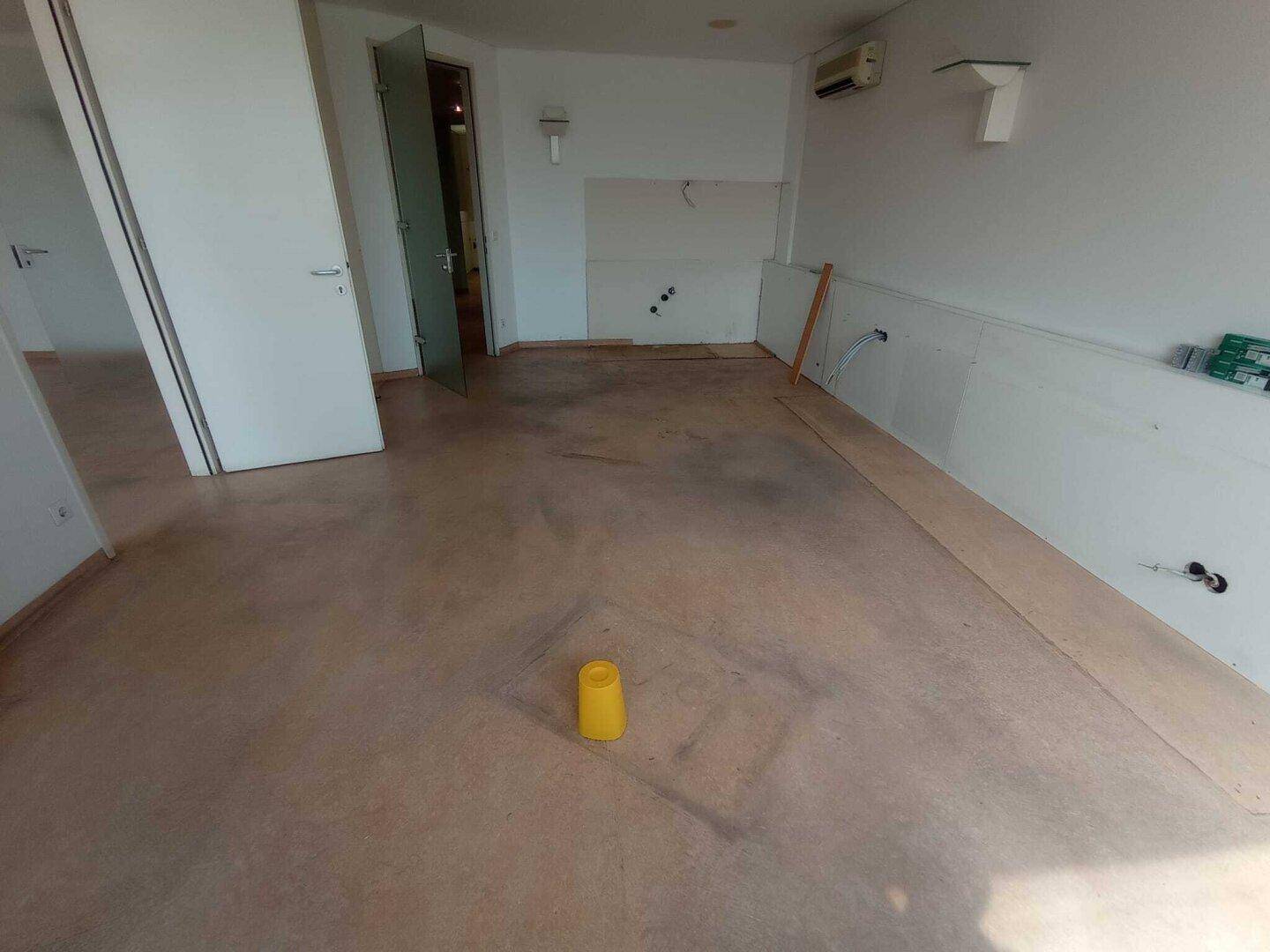Heller Raum mit Glastür und unbehandeltem Boden, bietet flexible Nutzungsmöglichkeiten und viel Licht.