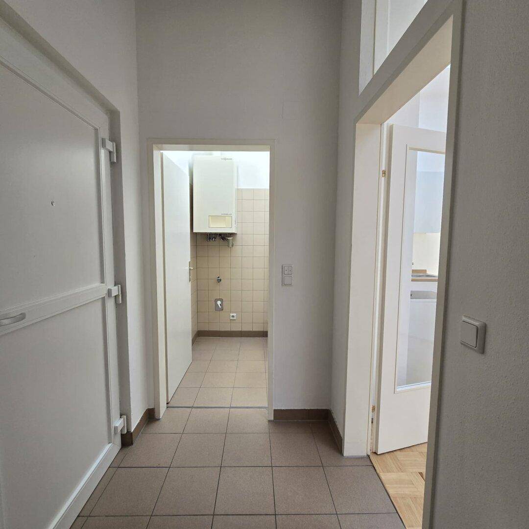 Eingangsbereich mit Fliesenboden und Zugang zu verschiedenen Räumen der Wohnung.