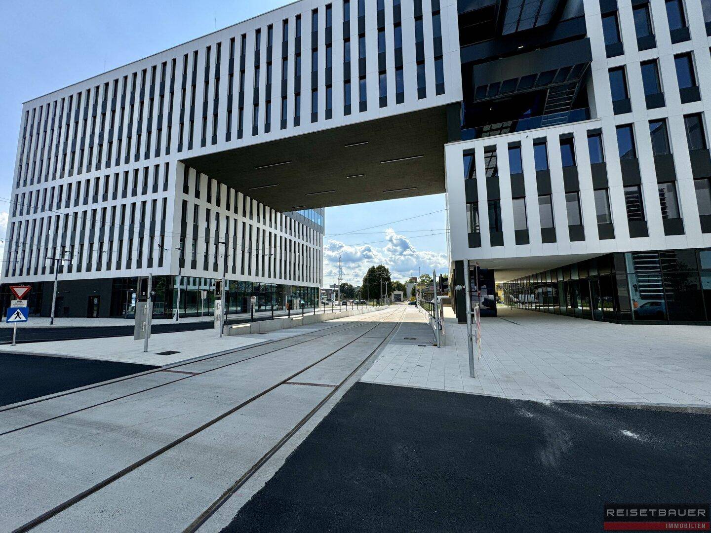 Beeindruckende moderne Bürogebäude mit einer Überführung über die Straße, gekennzeichnet durch klare Linien und große Glasflächen.