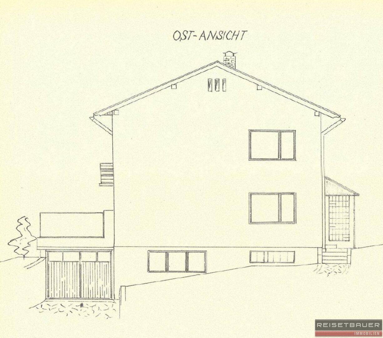 Ost-Ansicht des Hauses mit Giebeldach, Balkon und Garagenzugang.