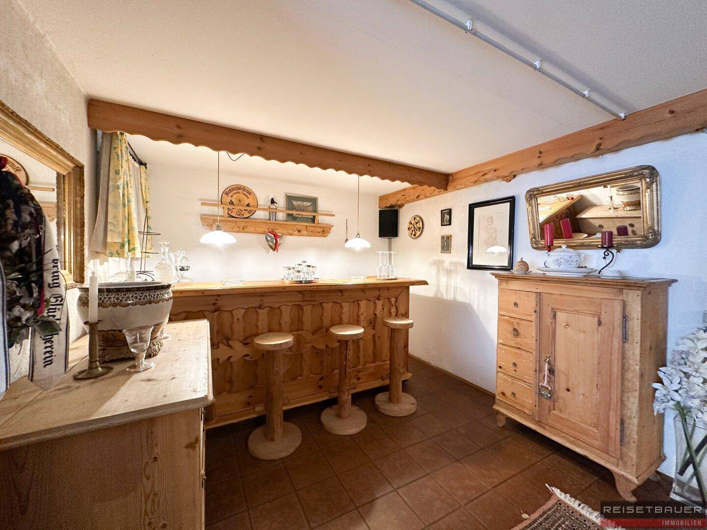 Gemütliche Hausbar mit Holzelementen, Barhockern und traditioneller Dekoration im rustikalen Stil.