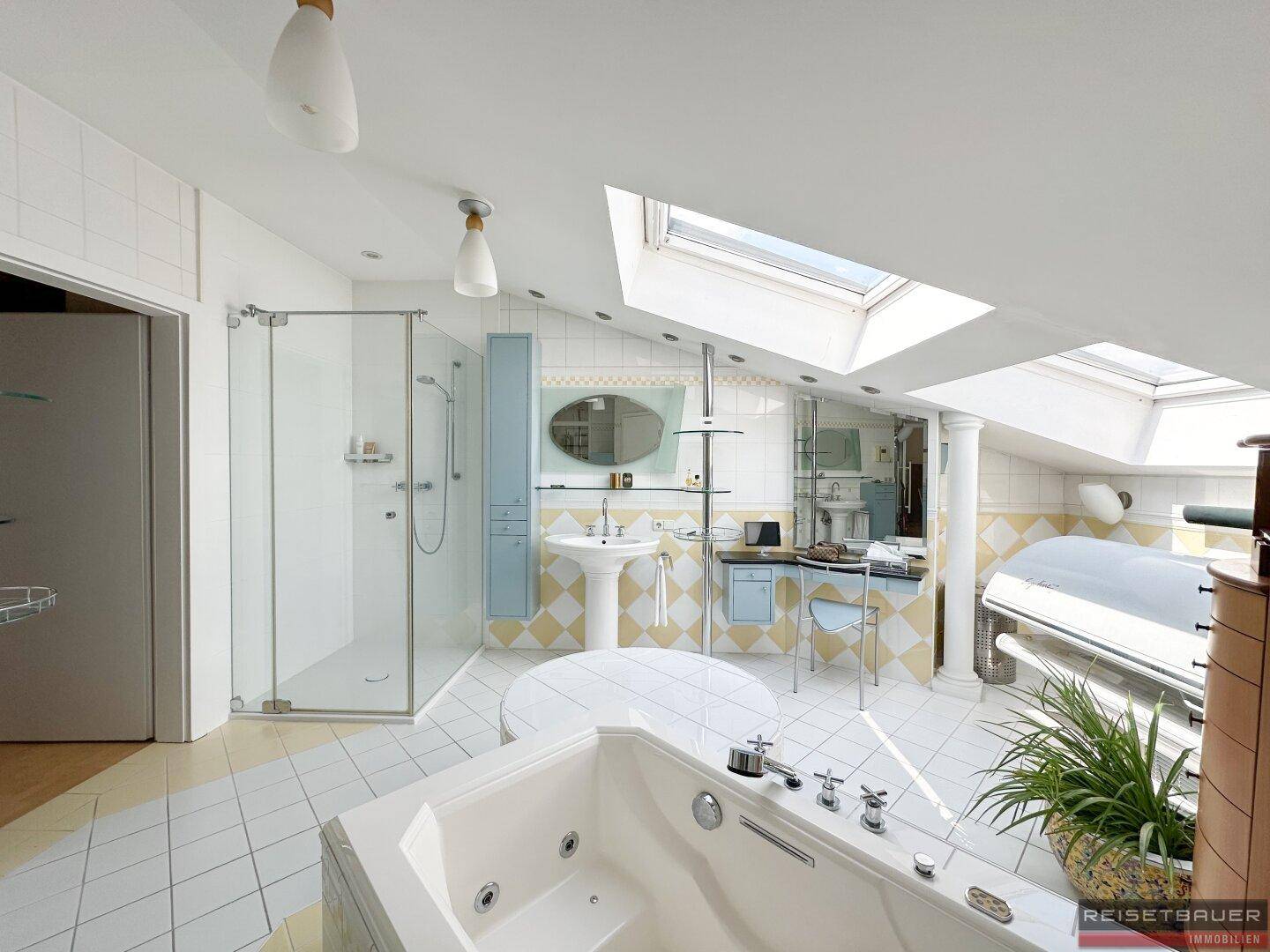 Geräumiges Badezimmer mit Badewanne, Duschkabine und Dachschrägen, die dem Raum Charakter verleihen.