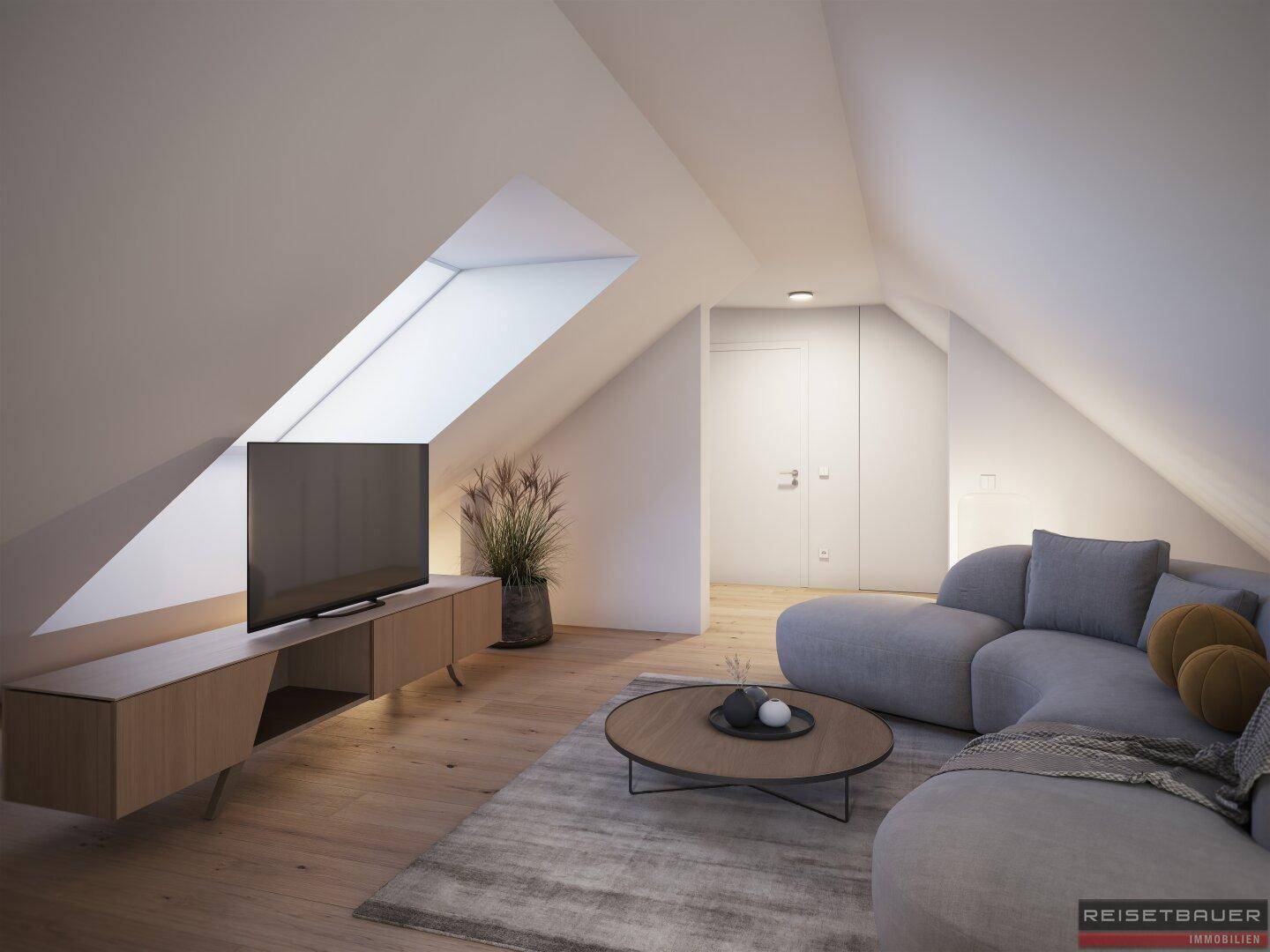 Gemütlicher Wohnbereich im Dachgeschoss mit Dachfenster, Holzboden und moderner Couch.