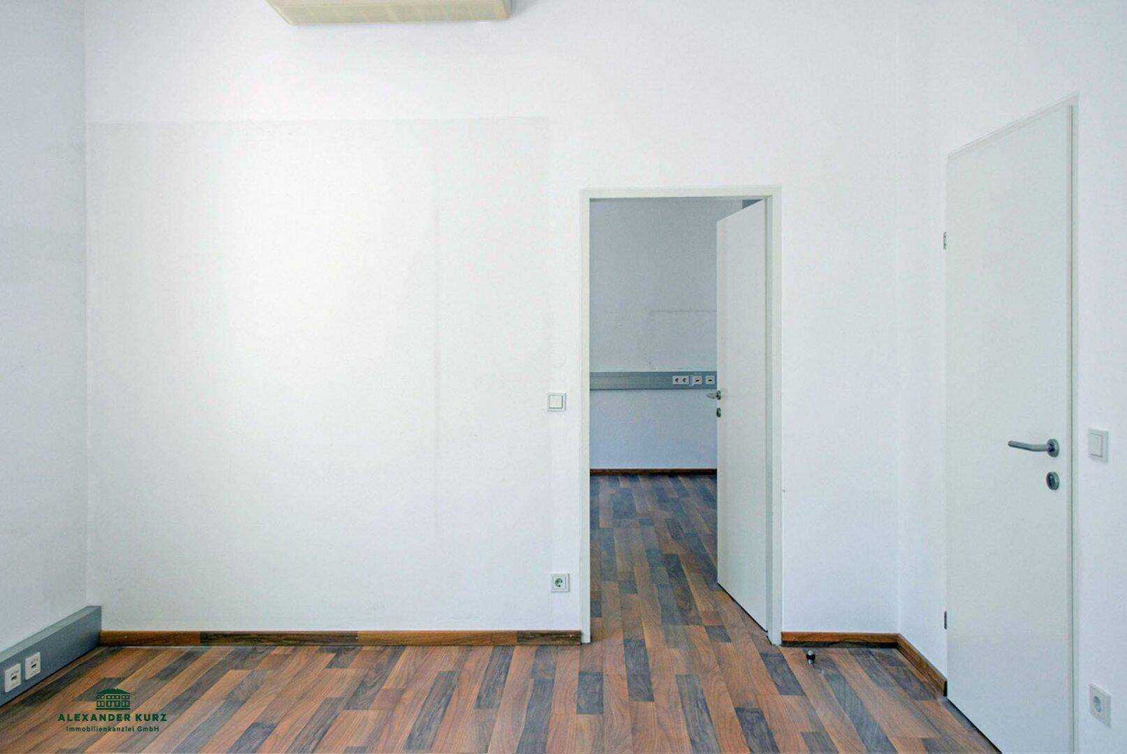 Heller, leerer Raum mit Laminatboden und weiß gestrichenen Wänden, ideal für verschiedene Nutzungen.