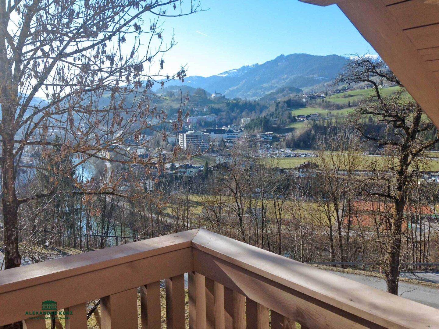 Panoramablick vom Balkon auf die Stadt, Berge und umliegende Landschaft an einem sonnigen Tag.
