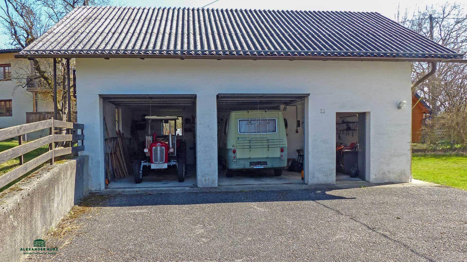 Doppelgarage mit zwei Stellplätzen, in denen ein Traktor und ein Fahrzeug stehen.