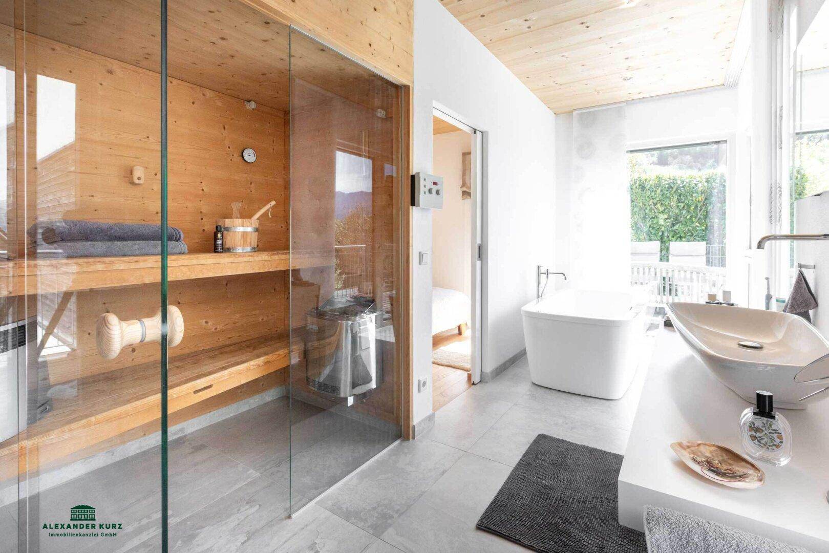 Modernes Badezimmer mit freistehender Badewanne, großem Waschbecken und integrierter Sauna.
