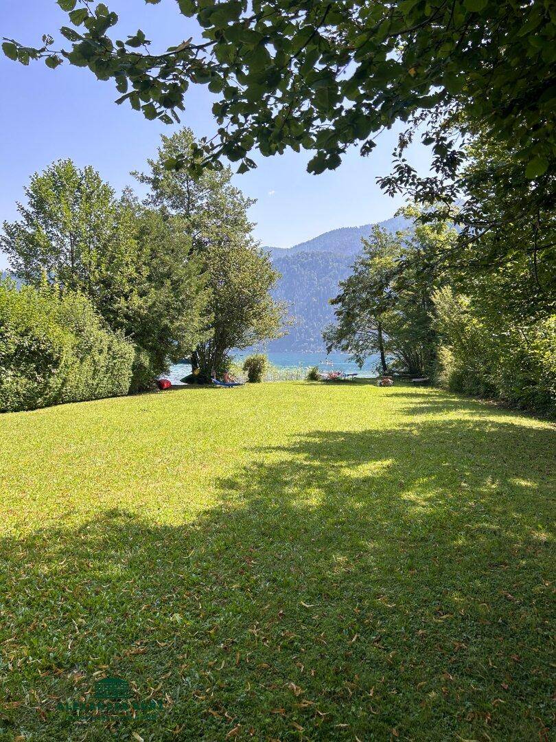 Großer, gepflegter Garten mit altem Baumbestand und idyllischem Blick auf den See.