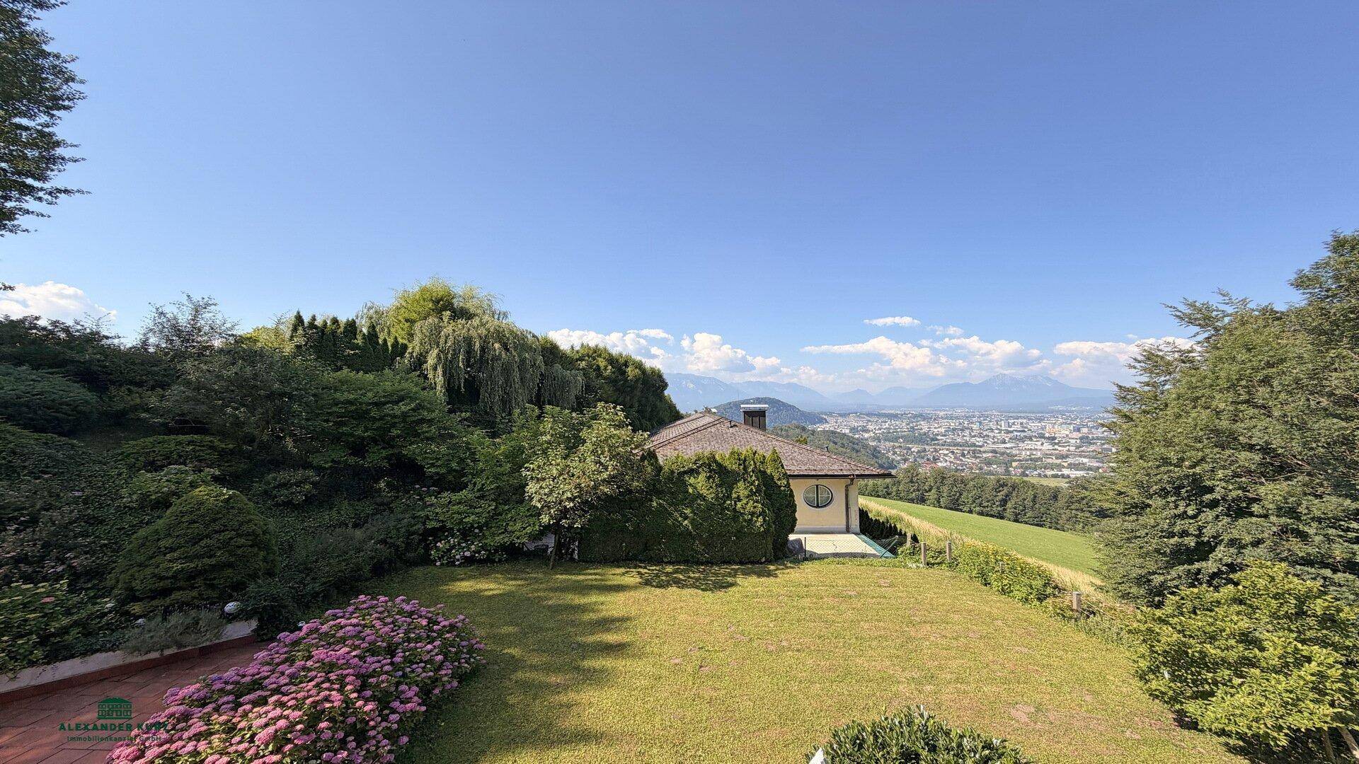 Gepflegter Garten mit Panoramablick auf die Stadt und die umliegenden Berge.