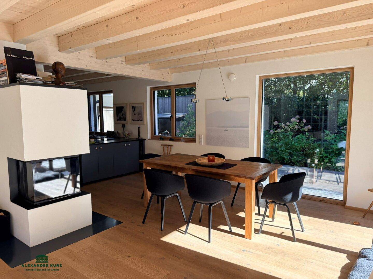 Moderner Essbereich mit Holztisch, dunklen Stühlen und einem stilvollen Kaminofen.