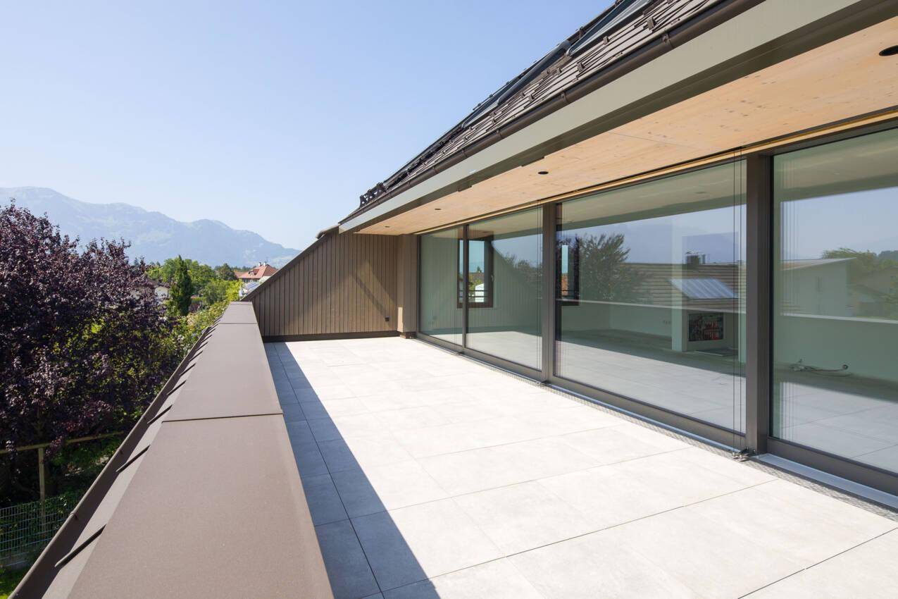 Weitläufige Terrasse mit großen Glasschiebetüren und einem herrlichen Blick auf die Berge.