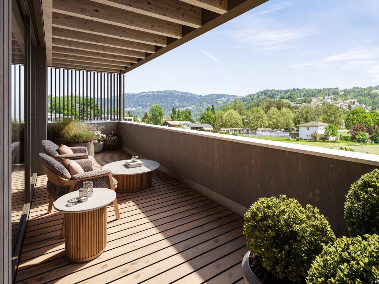 Geräumiger Balkon mit Holzboden, bequemen Sitzgelegenheiten und weitem Blick ins Grüne.