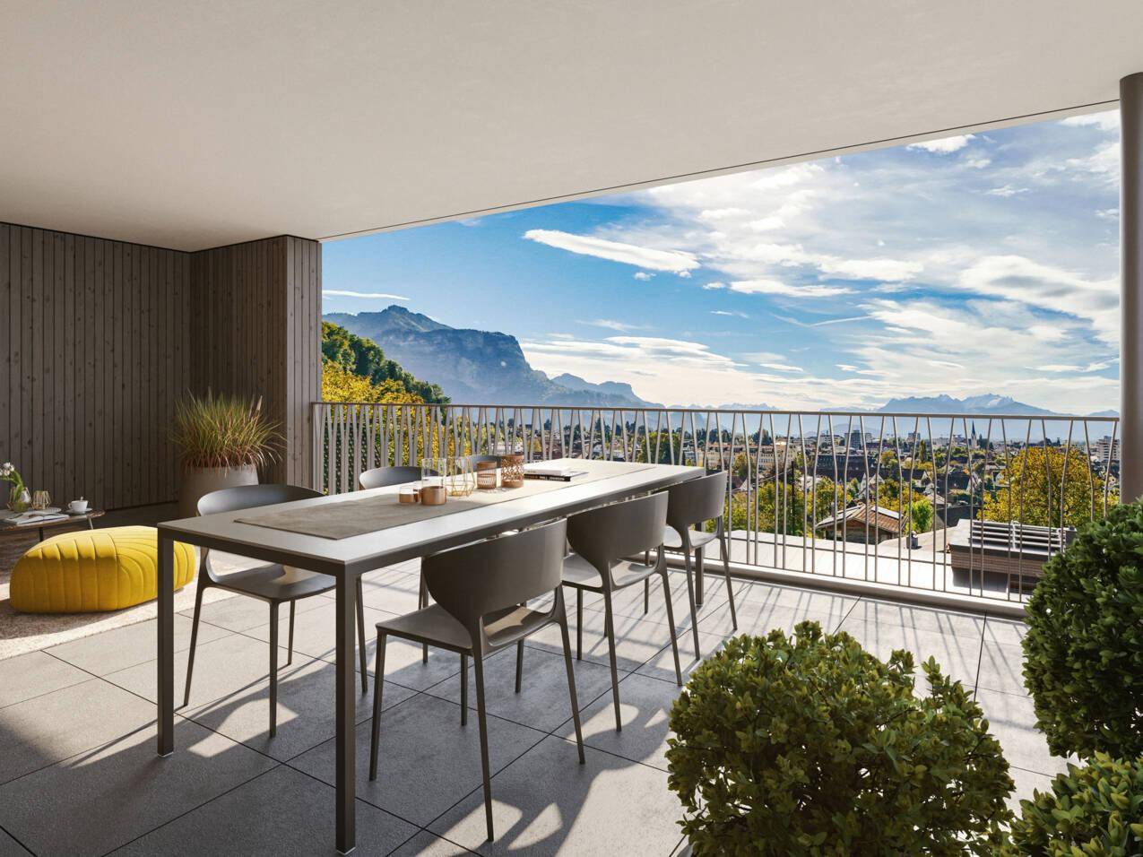 Weitläufige Terrasse mit Esstisch und Stühlen, bietet einen beeindruckenden Panoramablick auf die Berge.