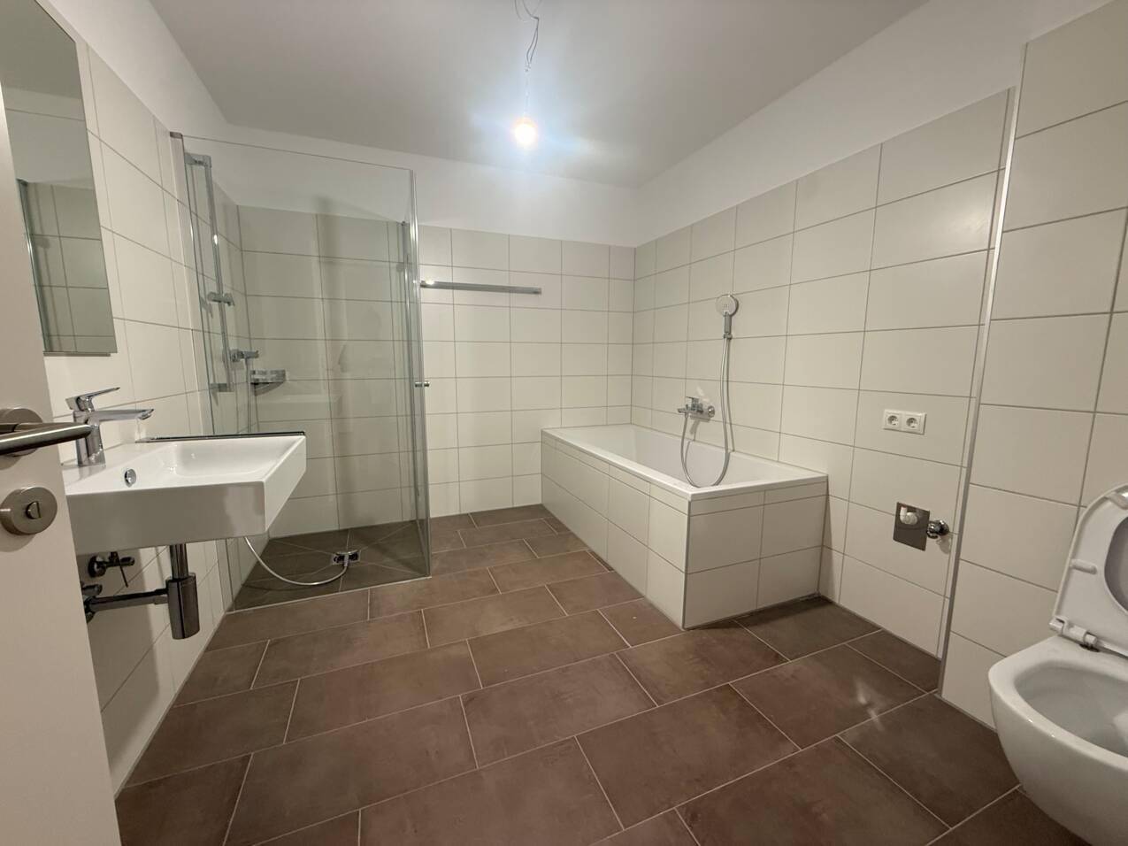 Geräumiges Badezimmer mit Badewanne, ebenerdiger Dusche, Einzelwaschbecken und Fliesenboden.