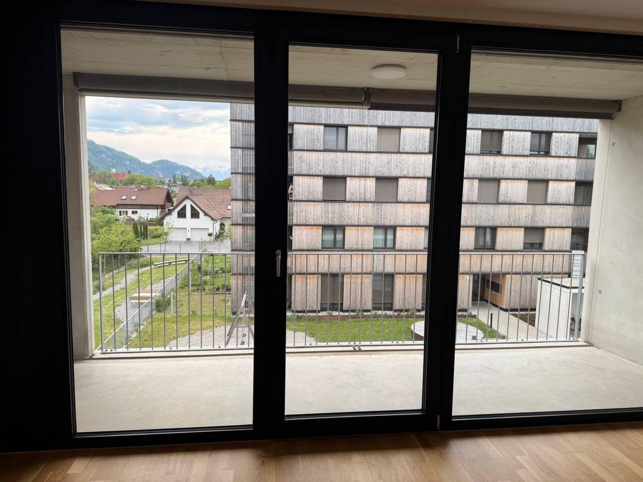 Weitläufiger Ausblick vom Balkon auf die umliegende Berglandschaft und grüne Umgebung.
