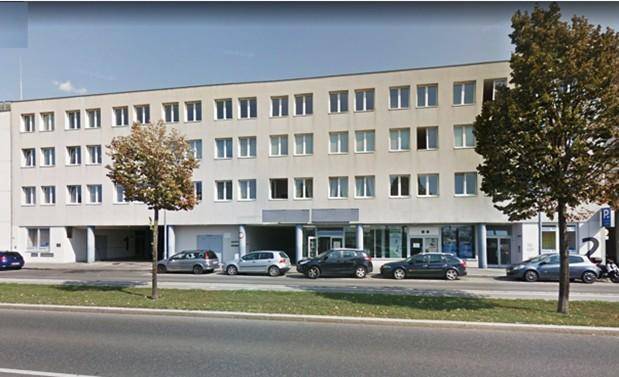 Wohngebäude mit Balkonen und einem gemeinschaftlichen Gartenbereich inklusive Spielplatz.