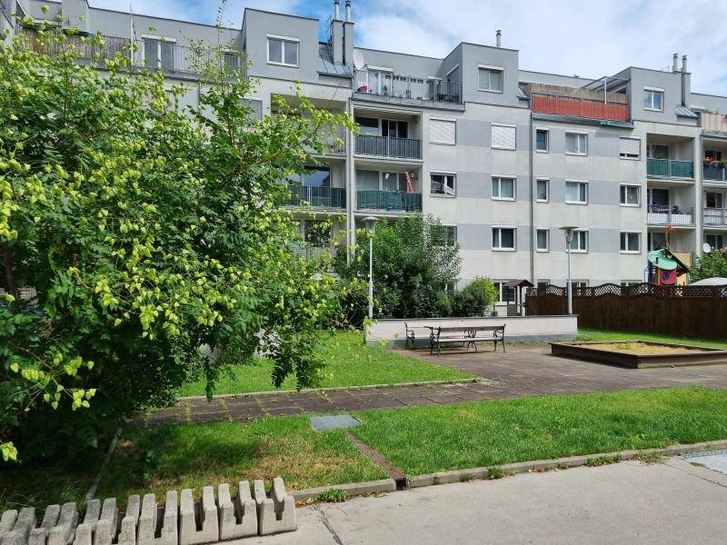 Helles Treppenhaus mit gefliestem Boden, Metallgeländer und Fenster für Tageslicht.