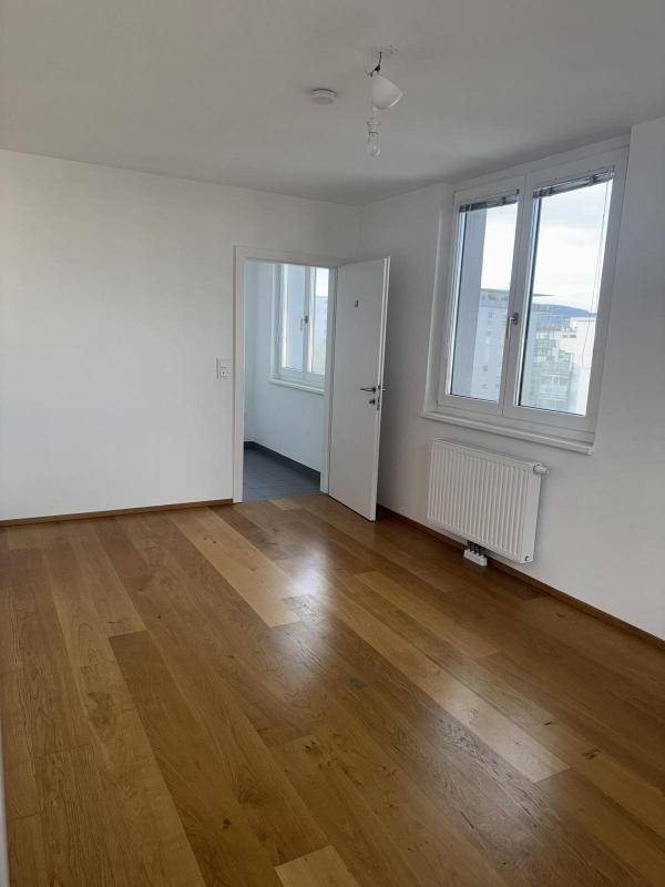 Kleiner Balkon mit Betonbrüstung und Blick auf die umliegenden Gebäude der Stadt.