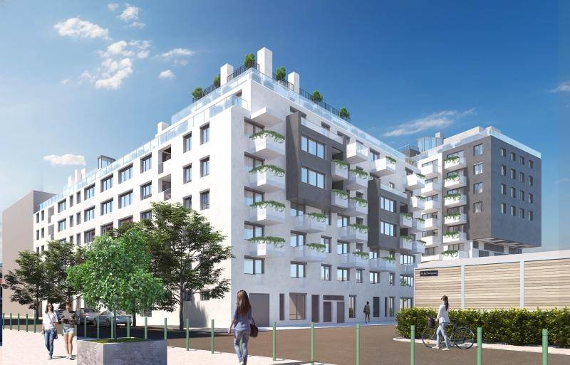 Moderne Wohnanlage mit mehreren Etagen, zahlreichen Balkonen und einer zugänglichen Dachterrasse in städtischer Umgebung.