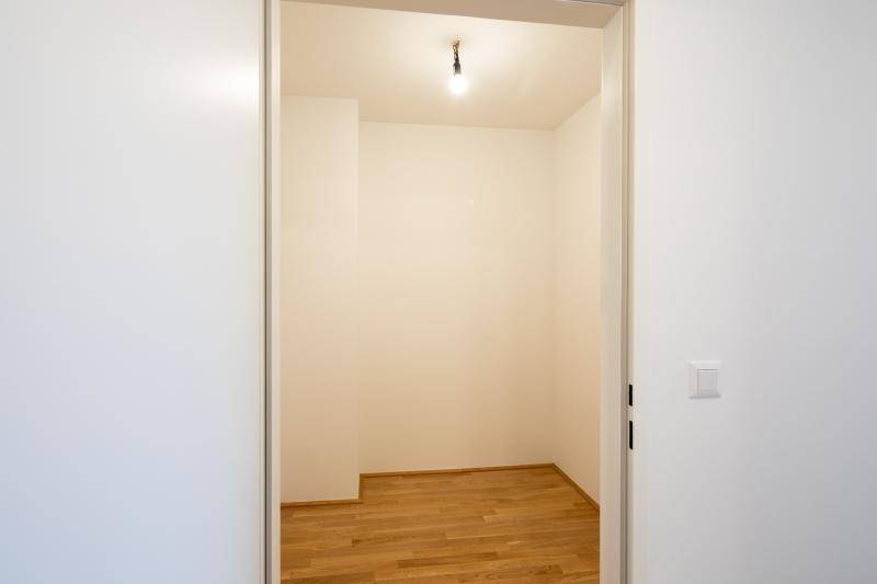 Kleiner, leerer Raum mit Holzboden und weißen Wänden, ideal als Abstellraum nutzbar.