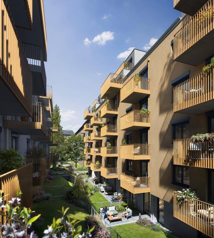 Eine moderne Wohnfassade mit hellen Wänden und auffälligen grünen Balkonen in urbaner Umgebung.