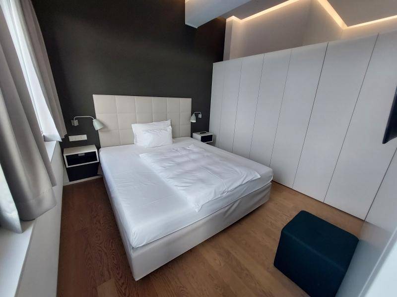 Modernes Schlafzimmer mit großem Doppelbett, integrierten Nachttischen und Einbauschränken.