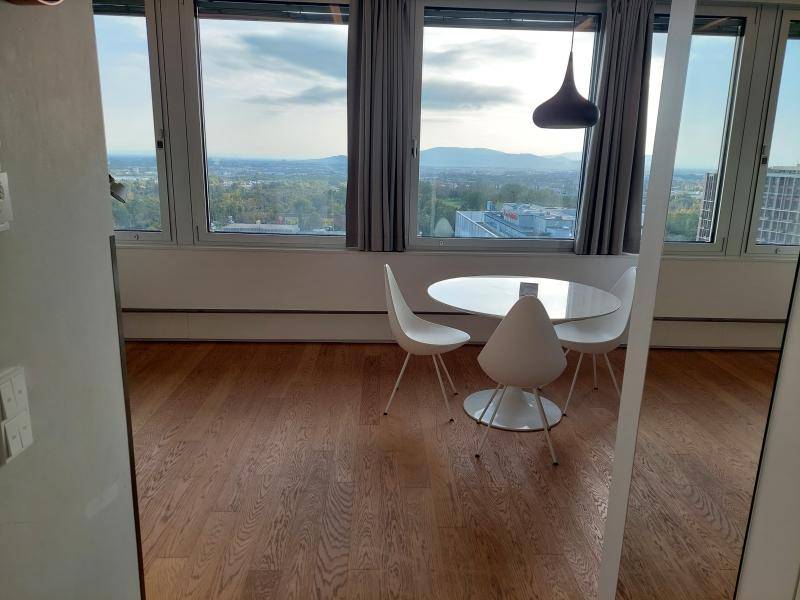 Heller Essbereich mit modernem runden Tisch und Stühlen, umgeben von großen Fenstern mit Panoramablick.