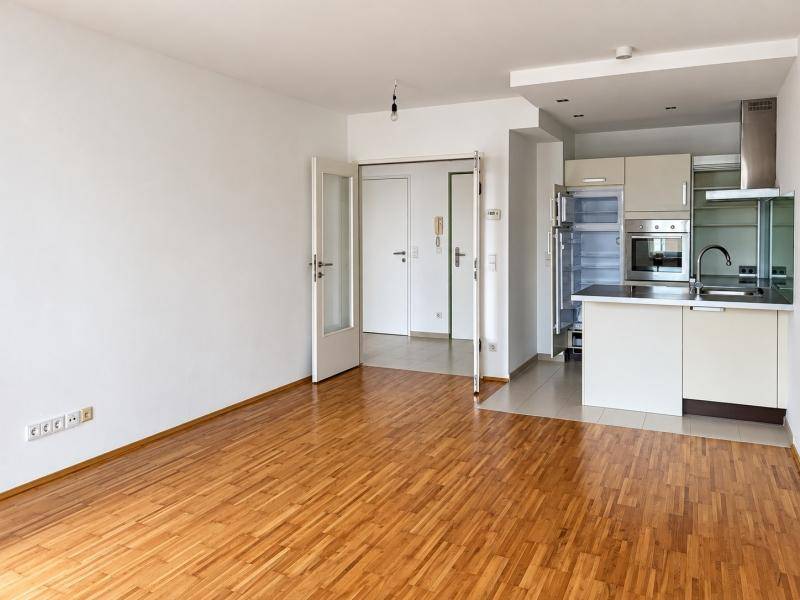 Offener Wohnbereich mit Holzboden und integrierter Küche im modernen Stil.