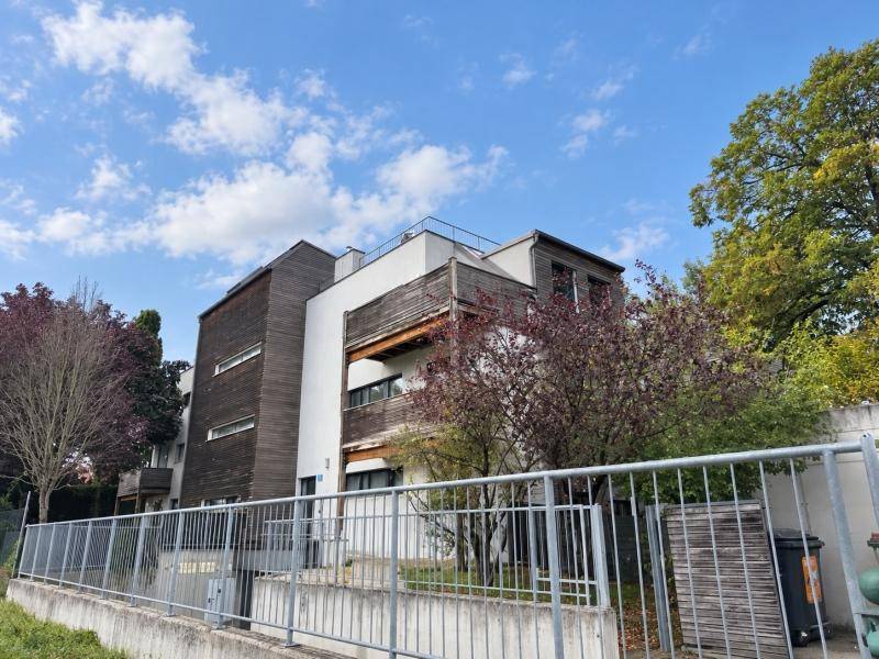 Ansicht des modernen Gebäudes mit Holzverkleidung und weißer Fassade unter blauem Himmel.