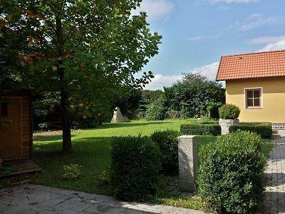 Großer, gepflegter Garten mit Rasenfläche, Sträuchern und einem kleinen Gartenhaus.