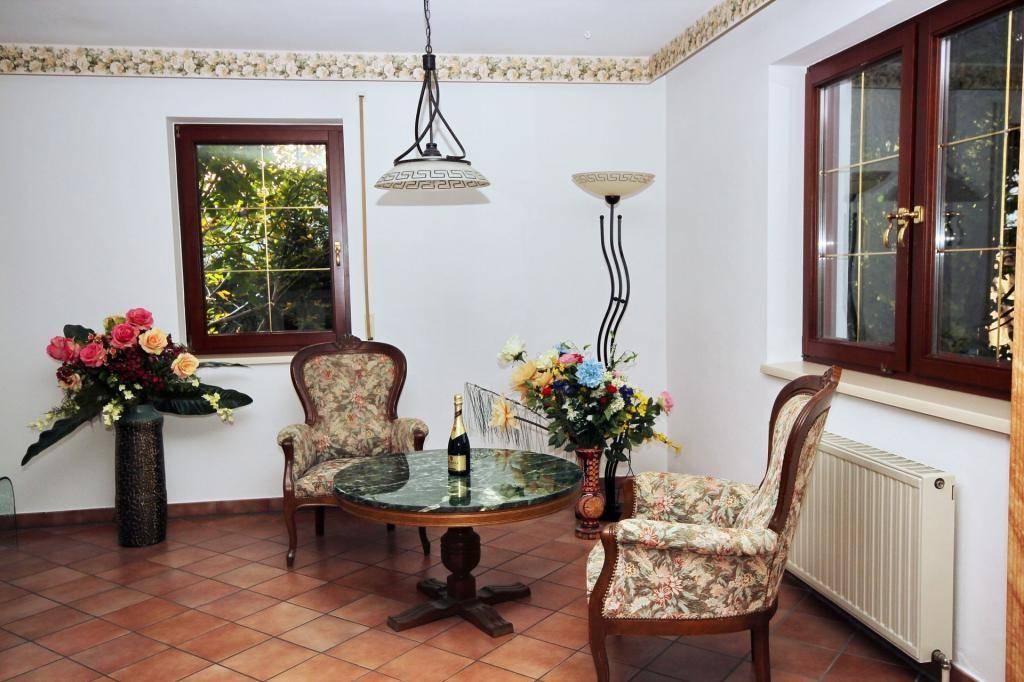 Gemütlicher Wohnbereich mit zwei Sesseln, rundem Tisch und Blick in den Garten.