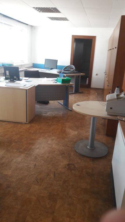 Helles Büro mit mehreren Arbeitsplätzen, Computern und einem Fenster, das Tageslicht hereinlässt.