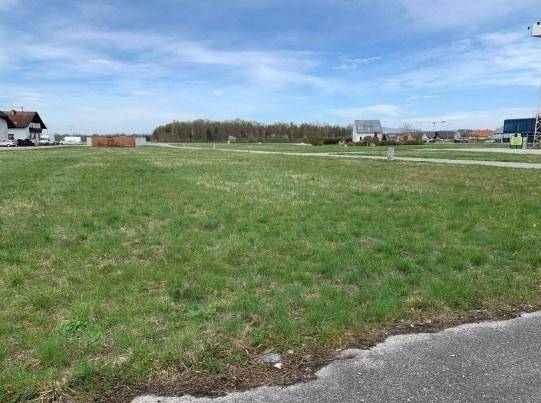 Weitläufiges grünes Grundstück mit Grasfläche und Blick auf die umliegende, leicht bebaute Landschaft.